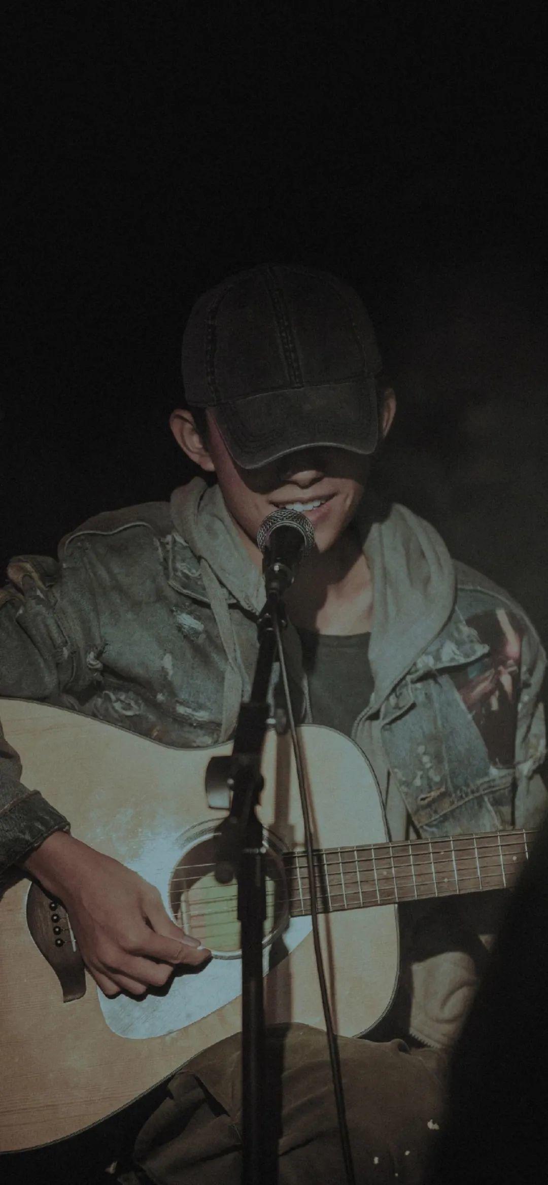 戴帽男生弹吉他深情演唱 壁纸