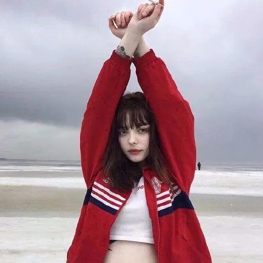 红衣女孩海边举手伸展照 头像