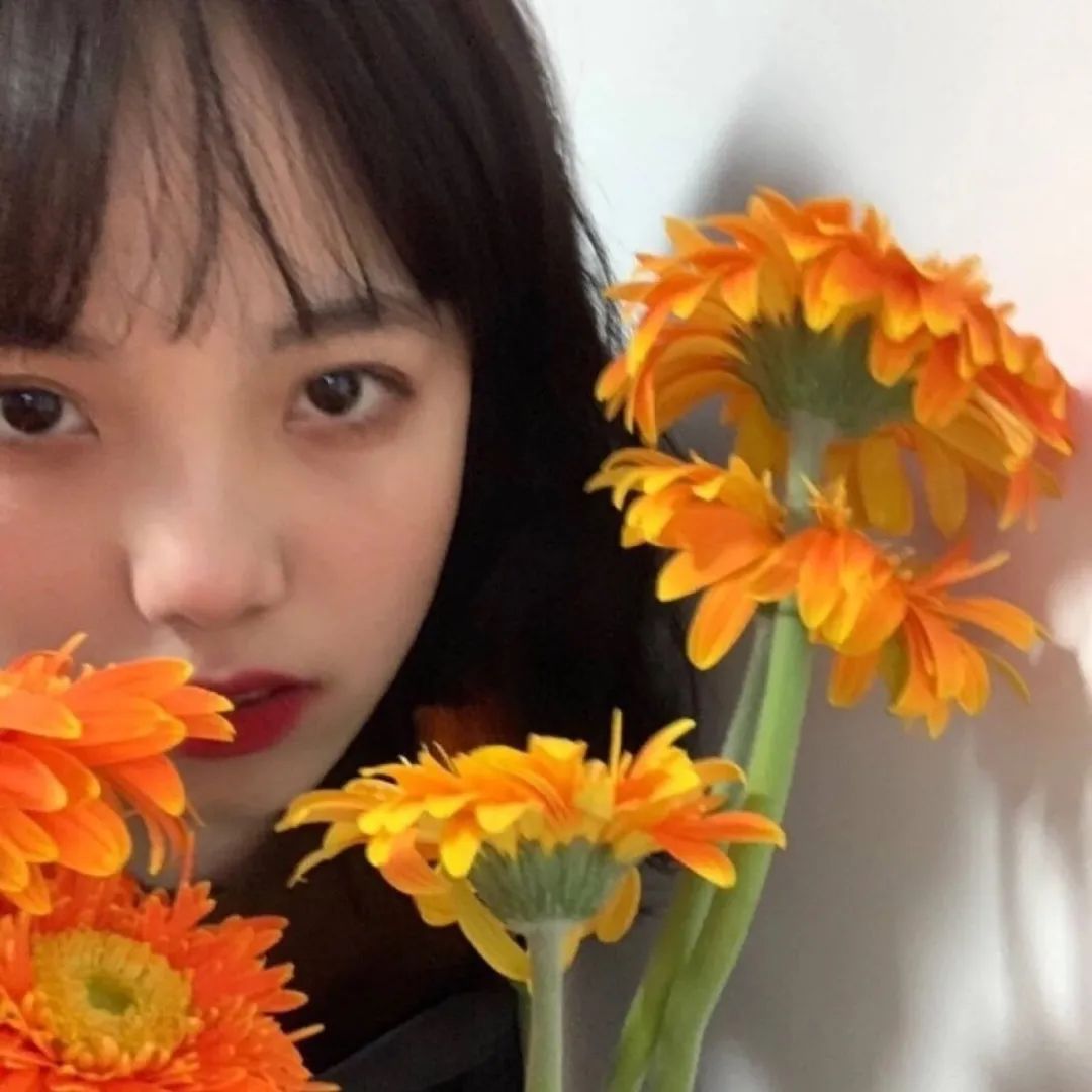 清新女生手持橙色花朵特写 头像