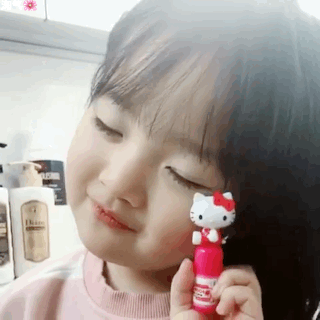 小女孩陶醉地闻Hello Kitty润唇膏 - 小孩表情包